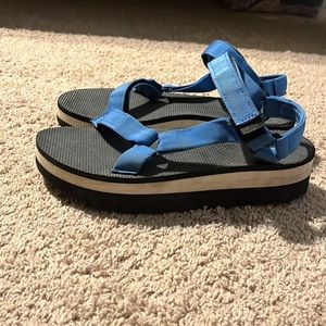 Black platform tevas with royal blue straps.